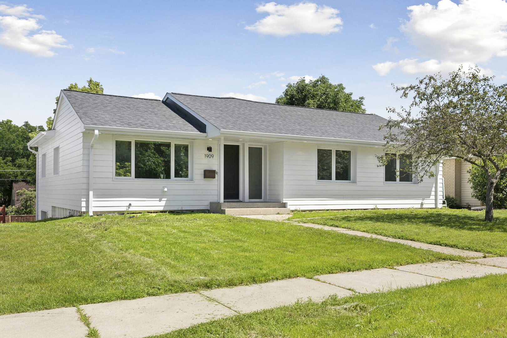 Front of house renovation with front lawn and white siding